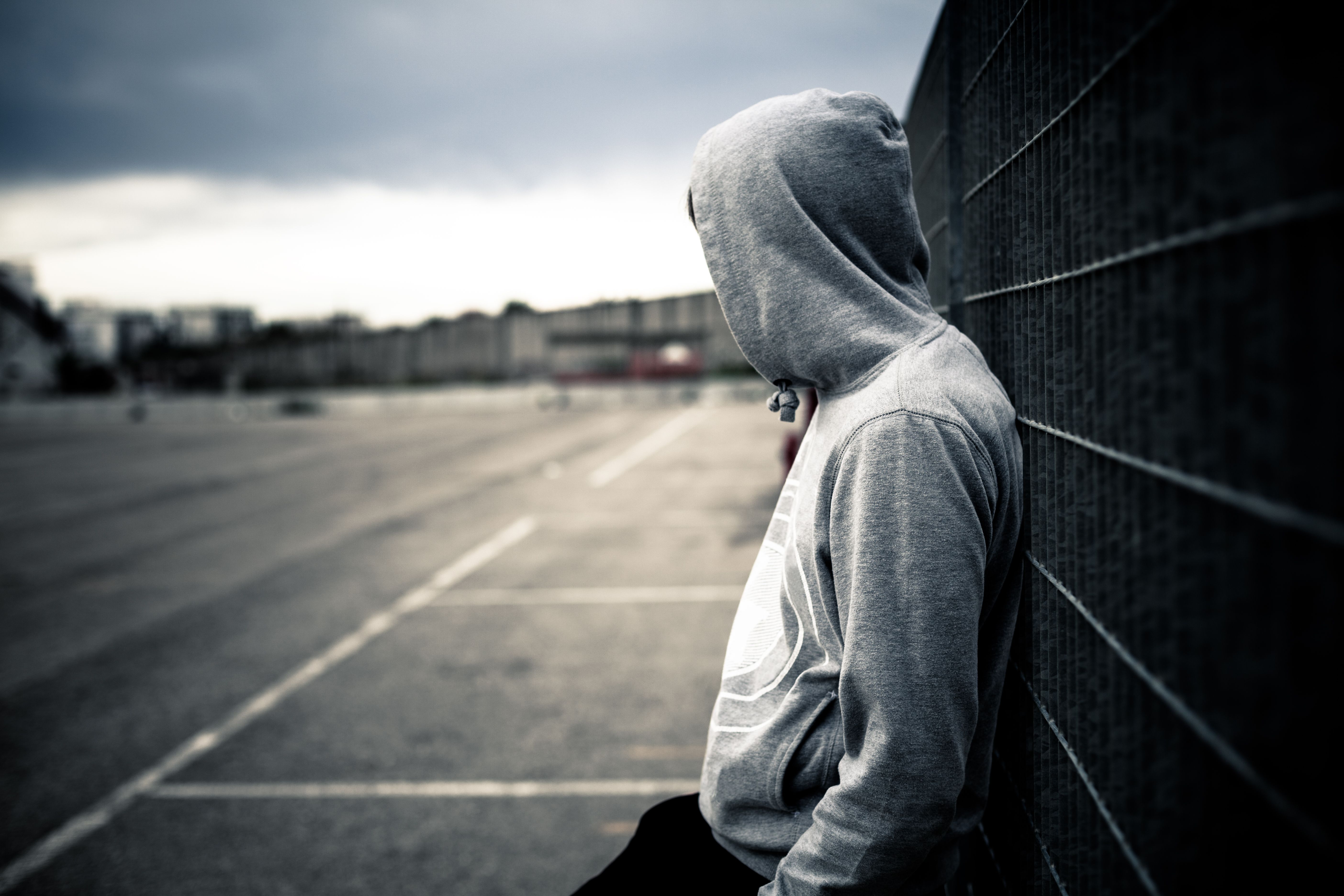 Image of the back of a young teen with a hooded jacket on. 